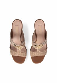 Sandales à enfiler à motif floral beige avec une boucle en or décorative. Matériau supérieur doux et semelle marron, comprenant une semelle intérieure rembourrée.