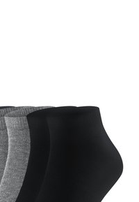 Four pairs of ankle socks in black and gray, arranged overlapping on a white background.