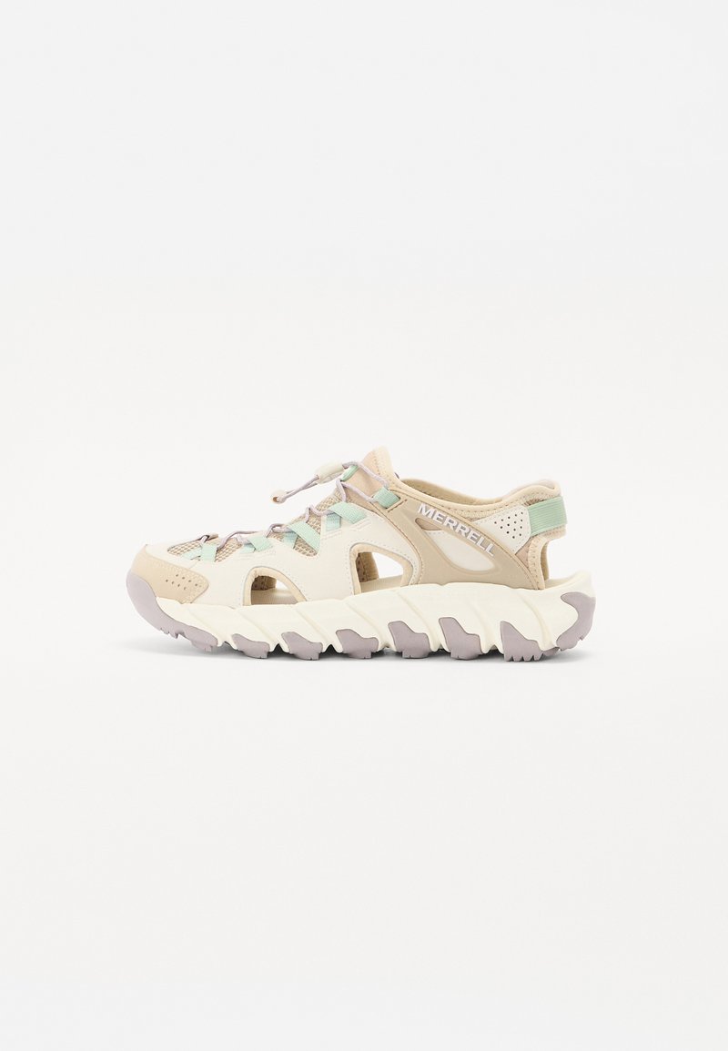 Light beige athletic shoes with cut-out design, featuring mint green accents, elastic laces, and a textured white sole with purple tread.