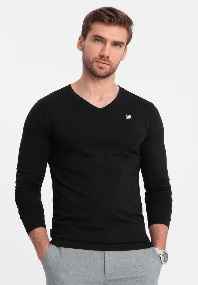 Svart långärmad V-ringad t-shirt i mjukt tyg. Har en liten logotyp på vänster bröst. Slimmad passform, utan mönster eller detaljer.