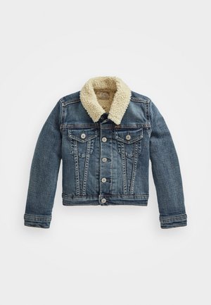 Kurtka dżinsowa z zapięciem na guziki, dwoma klapowymi kieszeniami na piersi i kremowym kołnierzem z materiału sherpa, rozłożona na płasko na białym tle.