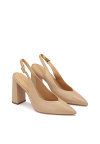 Beige Leder-Slingback-Absatzschuhe mit spitzen Zehen und Blockabsätzen, ausgestattet mit goldfarbenen, verstellbaren Riemen und Schnallen.