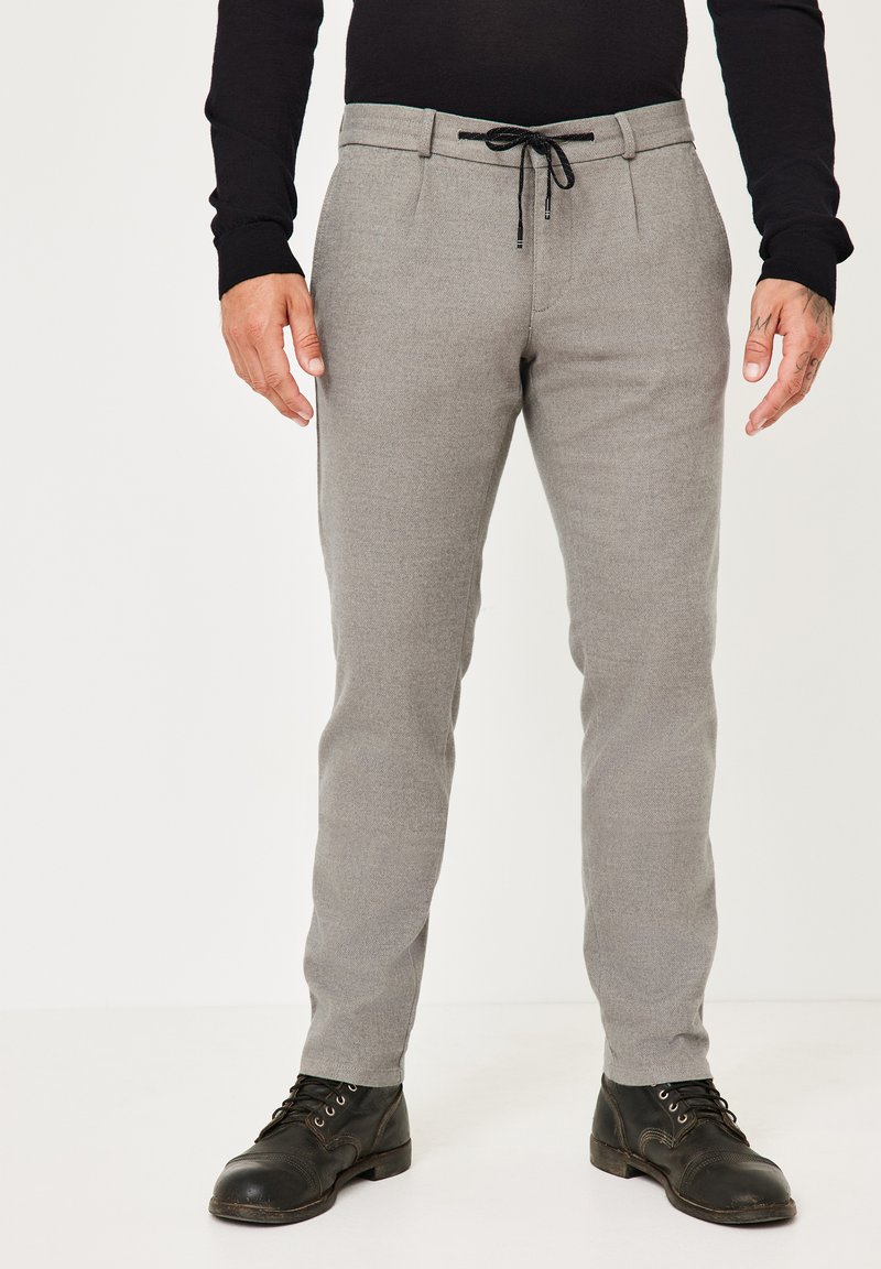Grau geschnittene Hose aus strukturiertem Stoff mit elastischem Kordelzugbund, ausgestattet mit zwei Fronttaschen und einem glatten Finish.