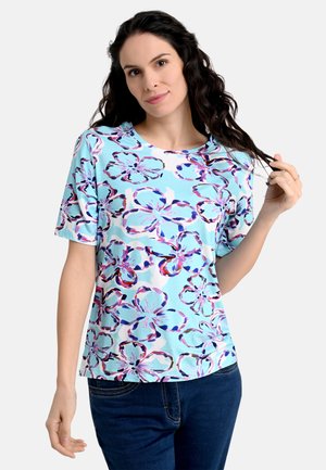 Hellblaues kurzärmliges Oberteil mit floralem Muster in lila und rosa Tönen. Hergestellt aus einem weichen, dehnbaren Stoff mit runden Ausschnitt.