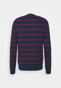 Pull bleu marine à manches longues avec fines rayures rouges horizontales, poignets et ourlet en côte, vu de dos.