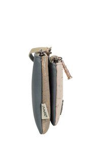 Billetera compacta con tres compartimentos en texturas gris, topo y rosa claro, con acentos metálicos y una etiqueta con el logo.