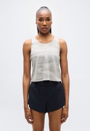 Ανοιχτό γκρι αμάνικο τοπ με υφή από δίχτυ, σετ με σκούρα μπλε σορτς. Το τοπ έχει στρογγυλή λαιμόκοψη και κομμένο μήκος.