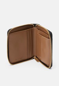 Fekete cipzáras pénzt�árca barna bőrbelsővel, több kártyatartóval és arany színű fém kiegészítőkkel. Simább tapintású és minimalista dizájnnal rendelkezik.