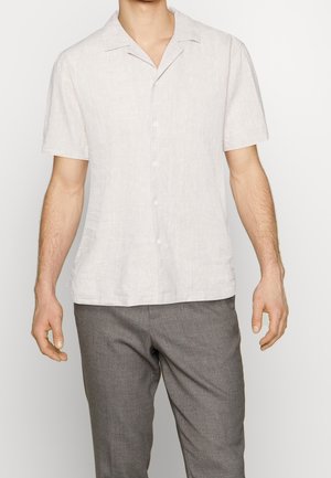 Chemise en lin léger gris clair à manches courtes, avec un col à revers et une coupe décontractée, assortie à un pantalon gris.