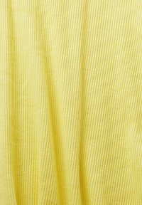 Gelbes strukturiertes Gewebe mit vertikalem Rippmuster. Das Material erscheint weich und leicht zerknittert, was einen leichten und luftigen visuellen Effekt erzeugt.