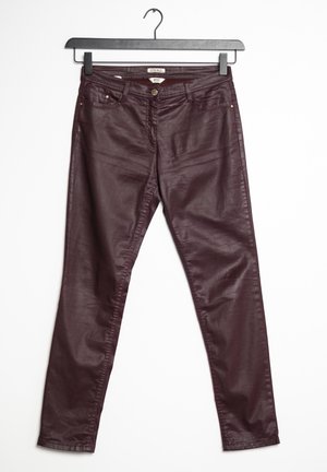 Bordeauxrote hose aus lederähnlichem Material mit schmaler Passform, ausgestattet mit einem Reißverschluss, Knopf, Messingbeschlägen und zwei Fronttaschen. Hängt an einem schwarzen Kleiderbügel.