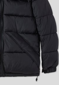 Giacca a vento nera con design trapuntato, chiusura con zip e polsini elasticizzati. Tessuto liscio e lucido con orlo regolabile e dettaglio della patta angolato.