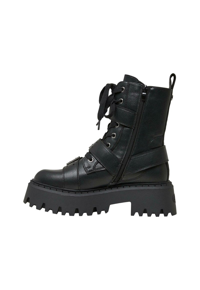 Botín negro de cuero hasta el tobillo con suela gruesa, cierre frontal con cordones, cremallera lateral y detalles de correas. Presenta una parte superior texturizada y un diseño de suela pronunciado.