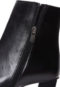 Czarne botki za kostkę o błyszczącej powierzchni, z bocznym zamkiem i słupkowym obcasem. Gładki skórzany materiał z minimalnymi detalami szycia.