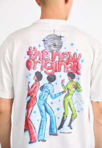 White T-shirt featuring a colorful graphic of three dancing figures in retro outfits, with a disco ball and stylized text above.