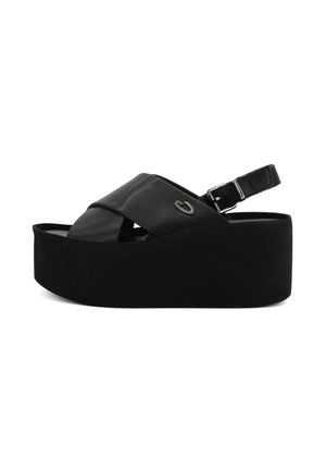 Sandali platform neri in pelle con design a fascette incrociate e fibbia regolabile. Presentano una texture morbida e un colore uniforme.