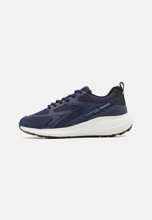 Granatowo-czarne sneakersy Lacoste z białą podeszwą, wiązaniem na sznurówki, teksturowanymi panelami i markowym logo na boku i pięcie.