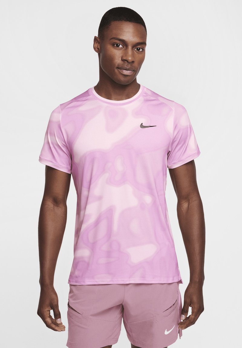 Camiseta deportiva para hombre de Nike en color rosa con un patrón ondulado, mangas cortas, escote redondo y un pequeño logotipo negro en el pecho. Textura suave.