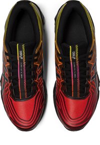 Scarpe da ginnastica rosse e nere con una tomaia testurizzata, caratterizzate da un design geometrico in sfumature di arancione e giallo, e lacci neri.