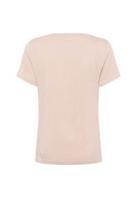 Ljusrosa T-shirt med kort ärm i mjukt tyg, med rund halsringning och en diskret logotypdetalj på baksidan nära nacken.