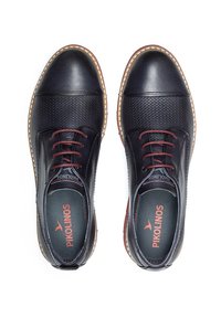 Chaussures en cuir bleu foncé avec une tige texturée, lacets bordeaux contrastants et une semelle cousue de couleur claire. Logo visible à l'intérieur.