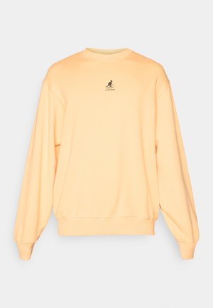 Light orange sweatshirt, cotton blend, crew neck, ribbed cuffs and hem, features small black logo on chest, relaxed fit, soft texture.