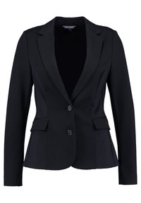 Mustapuku, jonka muotoilu on istuva, läpällä varustetut läpät, kaksi etutaskua ja kaksi nappia. Valmistettu sileästä kankaasta, jossa on jämäkkä siluetti.