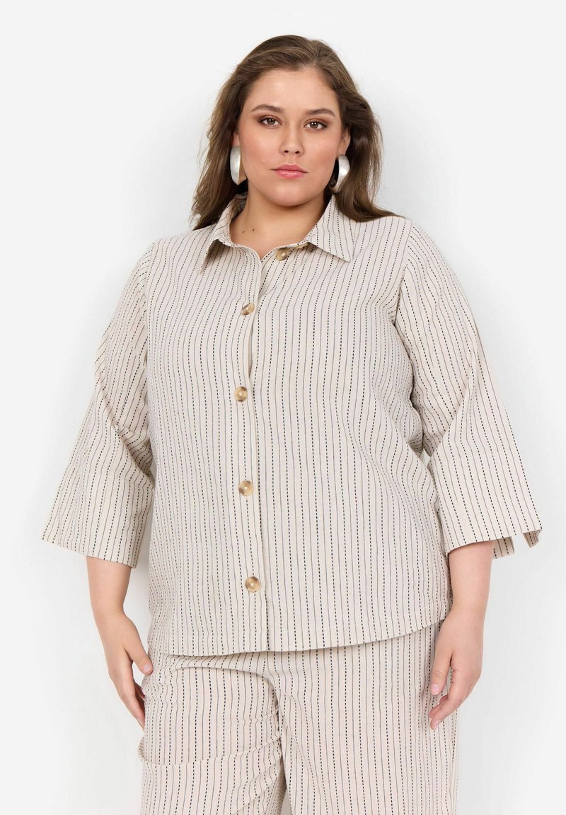 Stribet blouse med spidse krave, trekvart ærmer og frontknapper. Stoffet er let med en beige bund og mørke striber.
