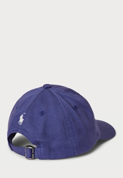 Lila bomull baseballkeps med broderad vit logotyp, justerbar rem bak och strukturerad frontpanel. Slät textur.