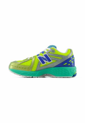 Heldere gele en groene hardloopschoen van New Balance met blauwe en grijze accenten en een dikke turquoise zool, zijaanzicht.