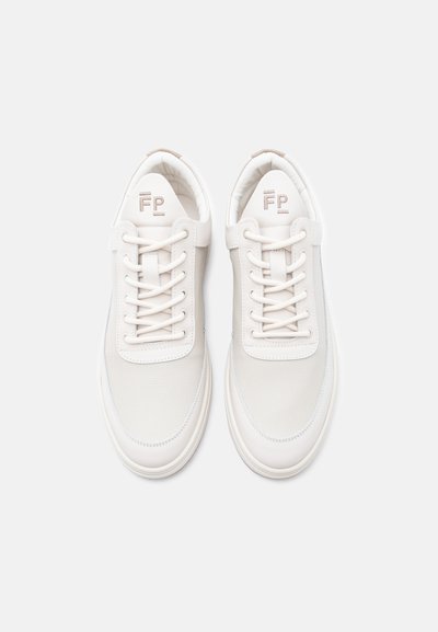 Ζευγάρι λευκά αθλητικά παπούτσια χαμηλού ύψους με κορδόνια και λογότυπο «FP» στη μαλακή γλώσσα, τοποθετημένα δίπλα δίπλα σε λευκό φόντο.