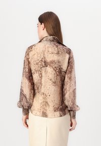 Brun slangeprint bluse med lange, pufferede ærmer, krave og elastiske manchetter. Glat stof med en subtil glans.