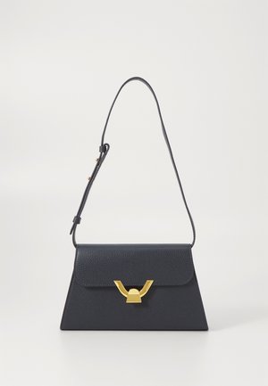 Bolsa de mão em pele azul marinho com formato triangular, aba dobrável e fecho em metal dourado. Apresenta uma alça fina ajustável.