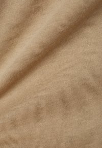 Beiger gerippter Stoff mit einer weichen Textur, der ein konsistentes Muster aus feinen Linien und leichtem Glanz aufweist, was auf ein leichtes Material hinweist.