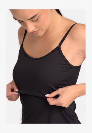 Černý bezrukávový top z hladkého, elastického materiálu; má tenké ramínka a zaoblený výstřih; ruce natáhnou lem pro úpravu.