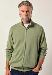 Maglione verde oliva con zip, texture a coste, colletto alto e maniche lunghe. Presenta una zip anteriore e un sottile dettaglio del logo sul petto.