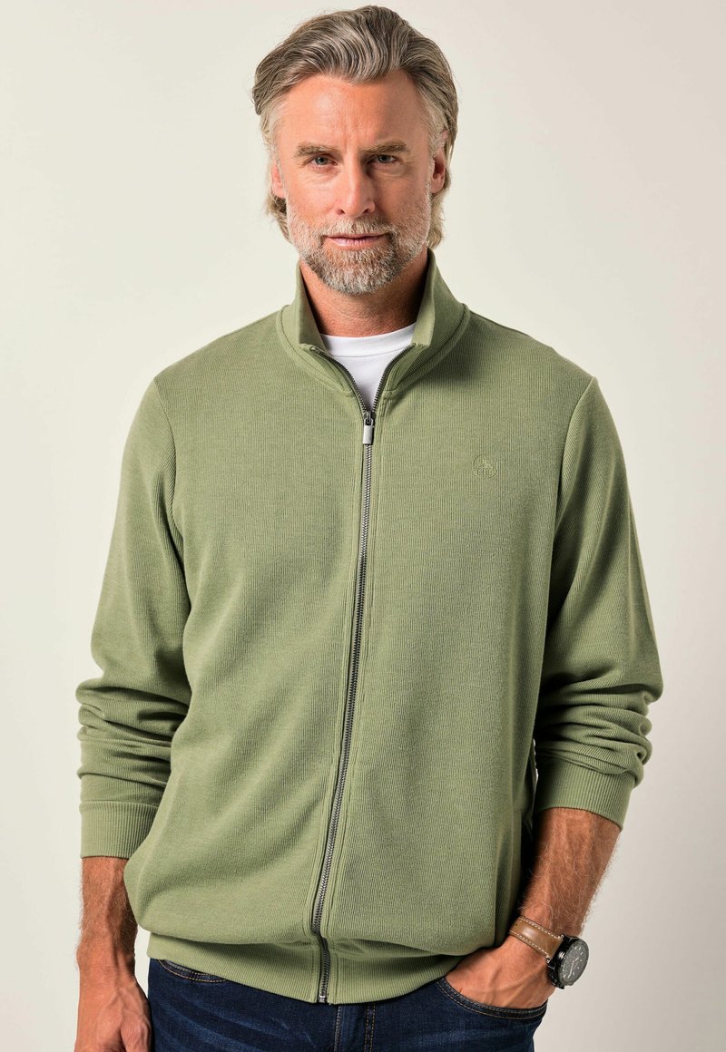 Maglione verde oliva con zip, texture a coste, colletto alto e maniche lunghe. Presenta una zip anteriore e un sottile dettaglio del logo sul petto.