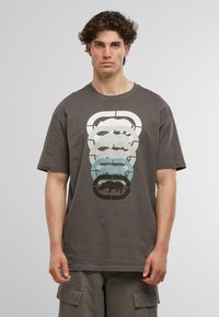 Grå kortærmet t-shirt med et flerlaget grafisk design af dyr i forskellige nuancer, med en afslappet pasform og blød tekstur.