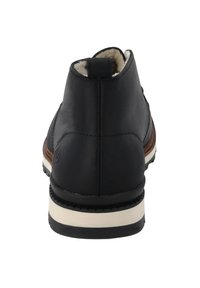 Schwarze Leder-Ankle-Boots mit einem weichen Innenfutter, weißer Zwischensohle und einer strukturierten Außensohle mit einem leichten Absatz.