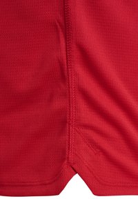Rode sportieve shorts van gestructureerde, ademende stof. Bevat zijsplitten en verstevigde stiksels langs de naden.