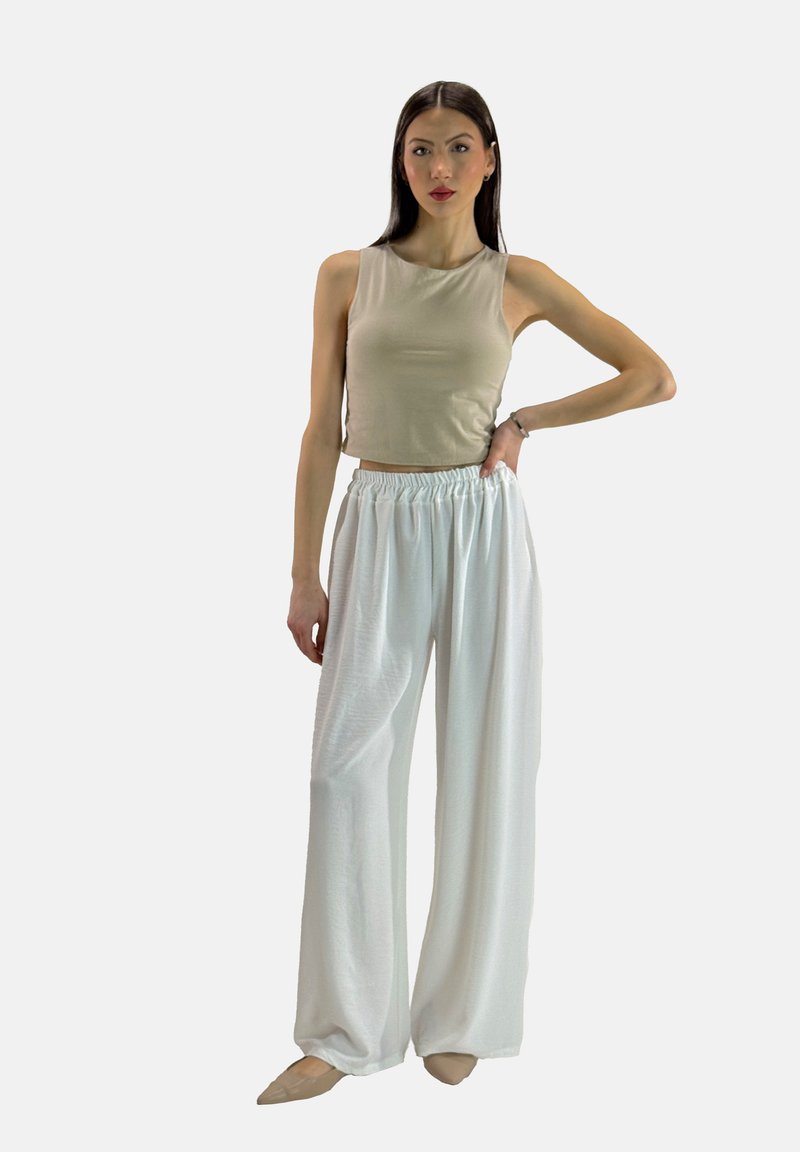 Beige kort tanktop sammen med hvide viddebukser. Glat stof, afslappet pasform og elastisk talje for komfort.