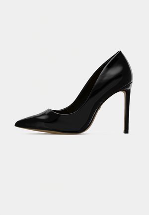 Fekete lakk bőr magassarkú cipő, hegyes orral és elegáns formával, 10 cm-es stiletto sarkú, sima, fényes felülettel.