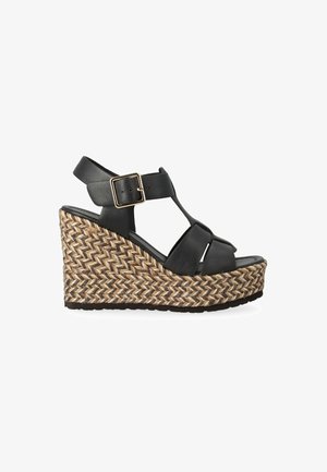 Sandalo zeppa in pelle nera con plateau in juta intrecciata, punta aperta, cinturino alla caviglia regolabile con fibbia dorata e cinturini incrociati sul piede.