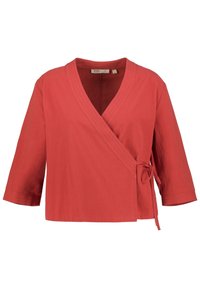 Rote Wickelbluse aus atmungsaktivem Stoff mit V-Ausschnitt, Dreiviertelärmeln und einer gebundenen Taillendetail.