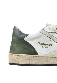 Sneaker bianca realizzata in materiali di pelle e suede. Accenti grigi e verdi, tacco testurizzato e suola beige. Dettaglio del logo dorato.