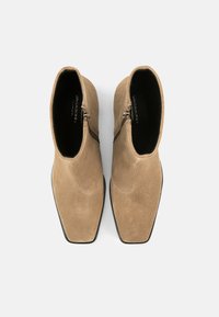 Tan suede ankle boots with a square toe, featuring a side zipper and smooth texture. Minimalist design without embellishments.