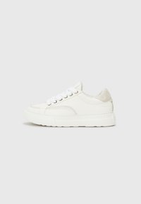 Baskets blanches en cuir et daim, avec un bout rond, un laçage à l'avant, une semelle en caoutchouc épaisse et de subtils détails de couture.