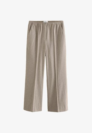 Beige vide bukser lavet af et blødt stof. Har en elastisk talje, sidelommer og en subtil tekstur.