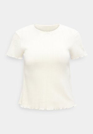 Bijela kratkih rukava, rebrasto pleteni top s okruglim izrezom i blago valovitim rubom na donjem dijelu i rubu rukava.