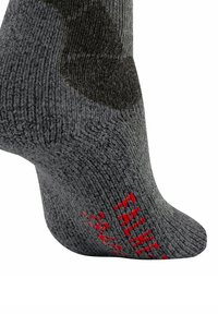 Szare dziane skarpetki o teksturowanej powierzchni, z czerwoną napisami po boku i wzmocnioną piętą.